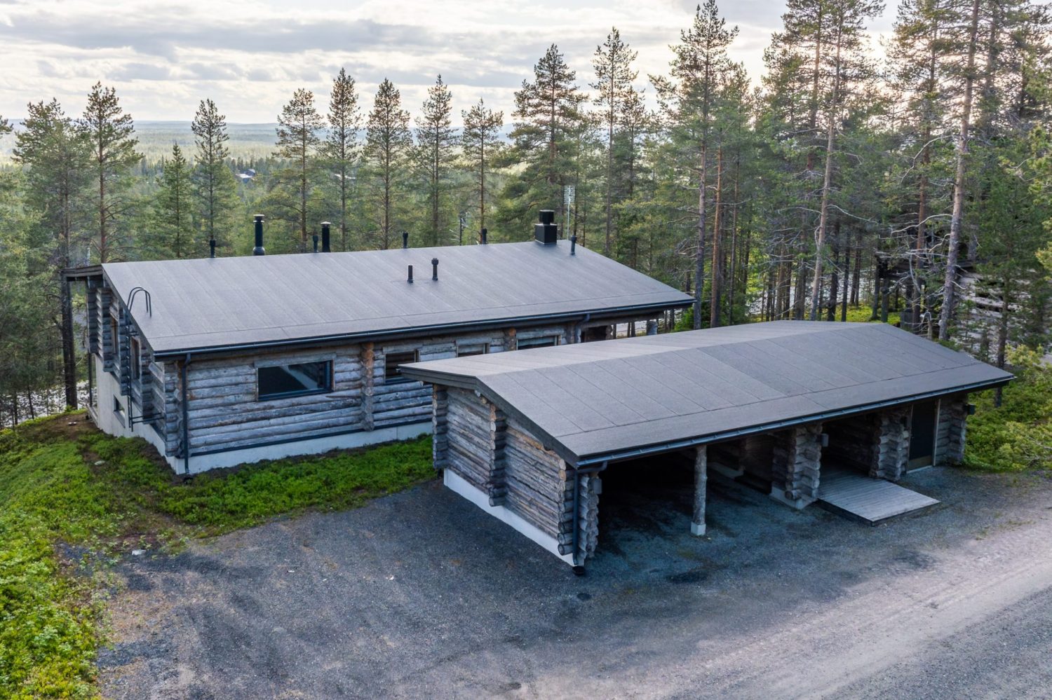 Villa Rinnekaltio ja erillinen autokatos kesällä, edessä sorapiha
