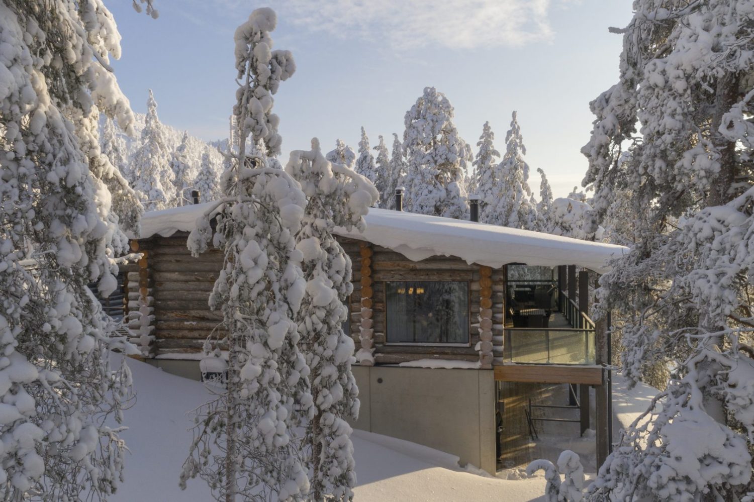 Villa Rinnekaltio tykkylumisten kuusten keskellä talvipäivänä