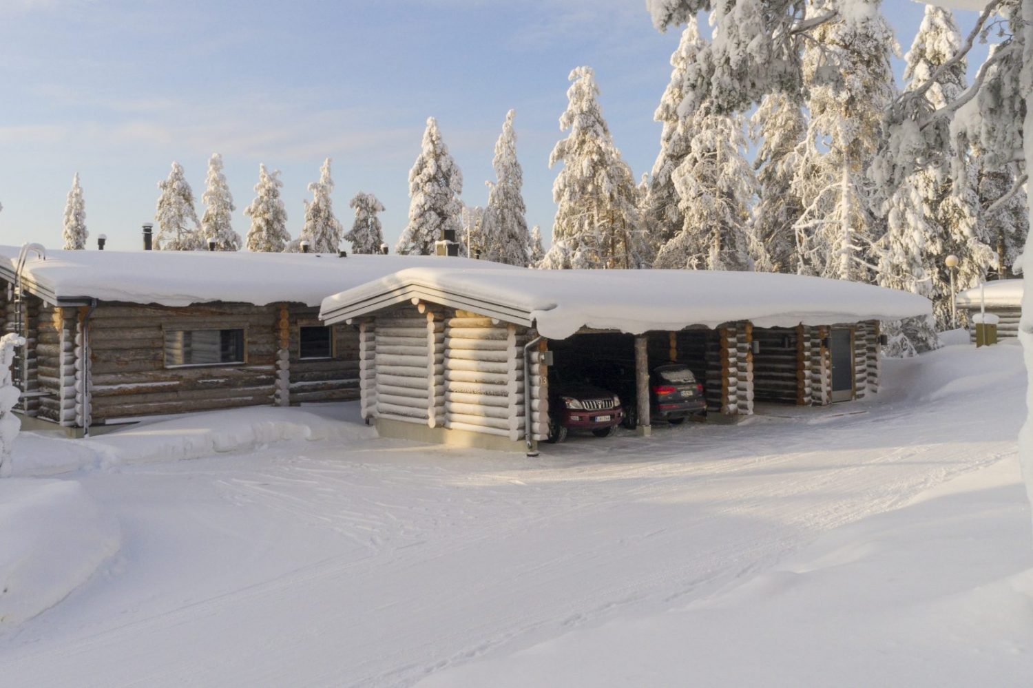 Villa Rinnekaltio ja autokatos lumen peittämässä metsässä
